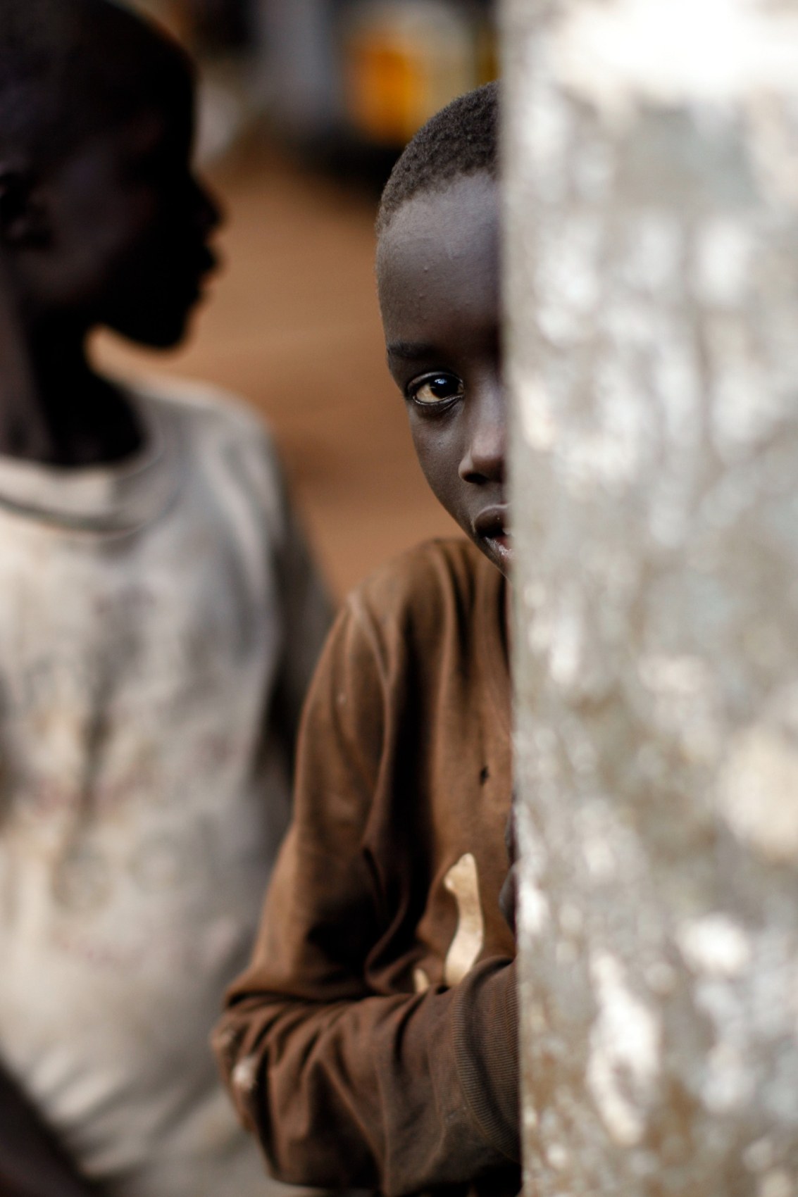 Child partly hidden beside a wall